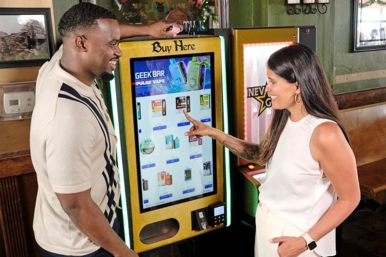 Customers browsing a NiteStock vending machine inside a bar